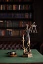 Lady Justice and gavel on a table in a classic law library setting.